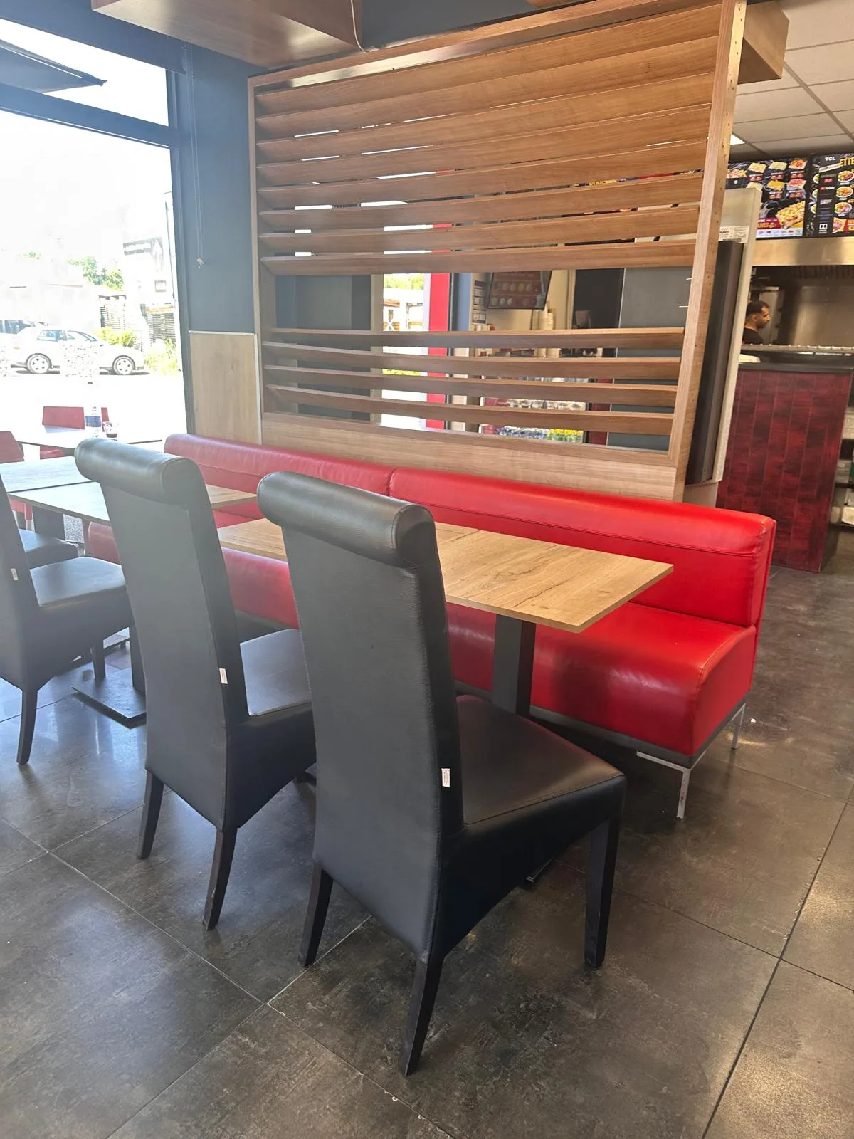 Banquette rouge avec séparateur claustra bois — coin convivial