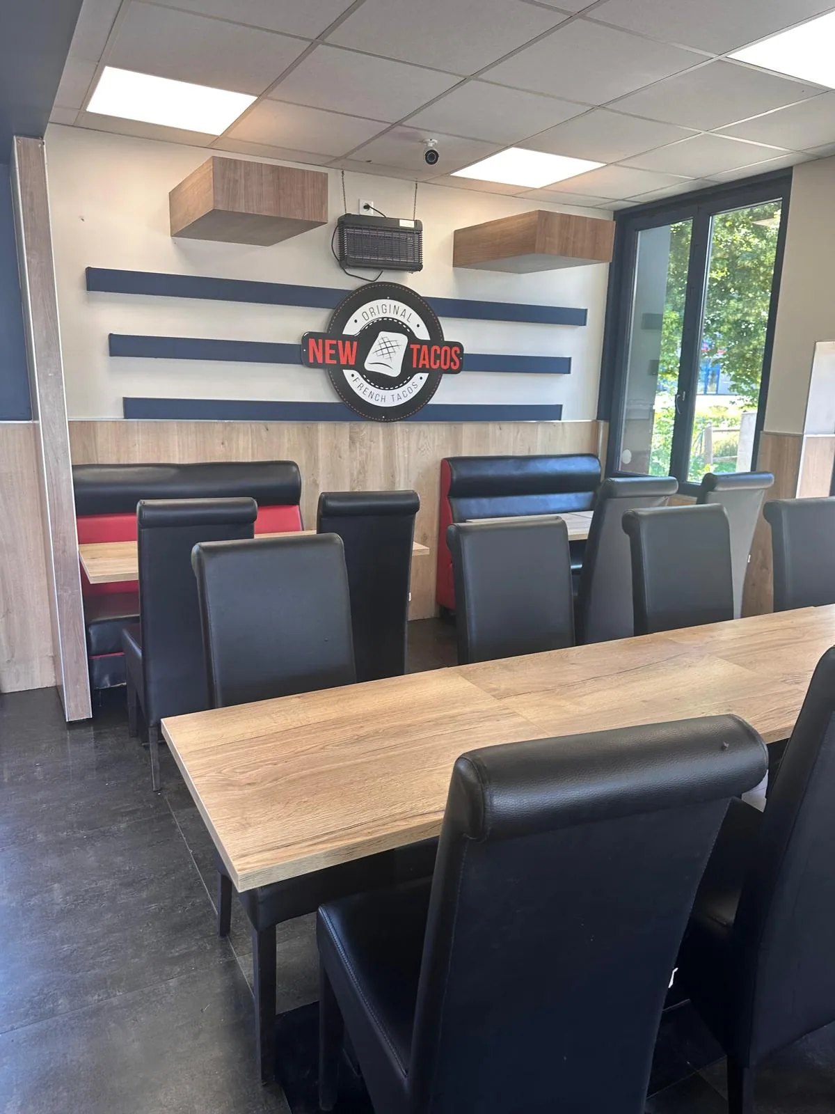 Salle à manger New Tacos avec le logo sur le mur et les bandes navy/rouge signature