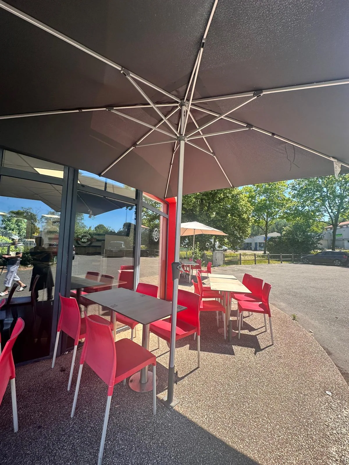 Terrasse extérieure de New Tacos Cahors — chaises rouges sous les parasols
